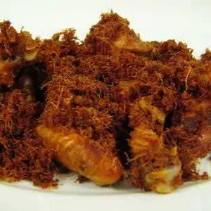 Potongan ayam kampung goreng laos disusun di piring putih