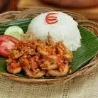 Nasi putih berbentuk kerucut bersama udang geprek dan sambal di atas anyaman bambu