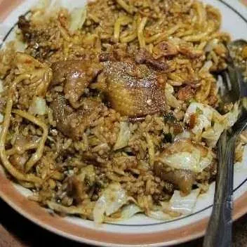 Nasi goreng jawa dengan irisan ayam dan kubis di piring putih